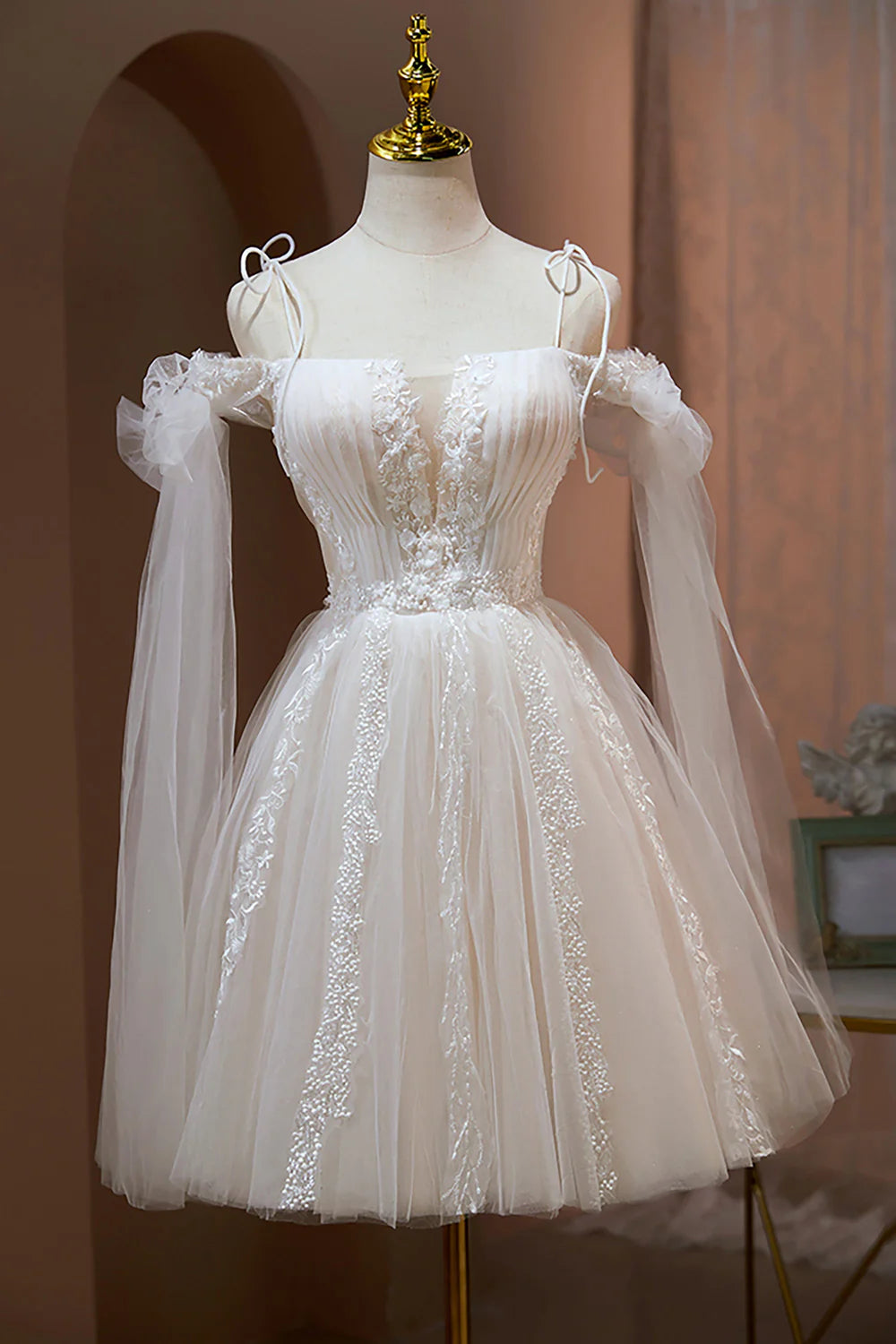 Elegant short tulle dress featuring A-line silhouette and floral appliques.