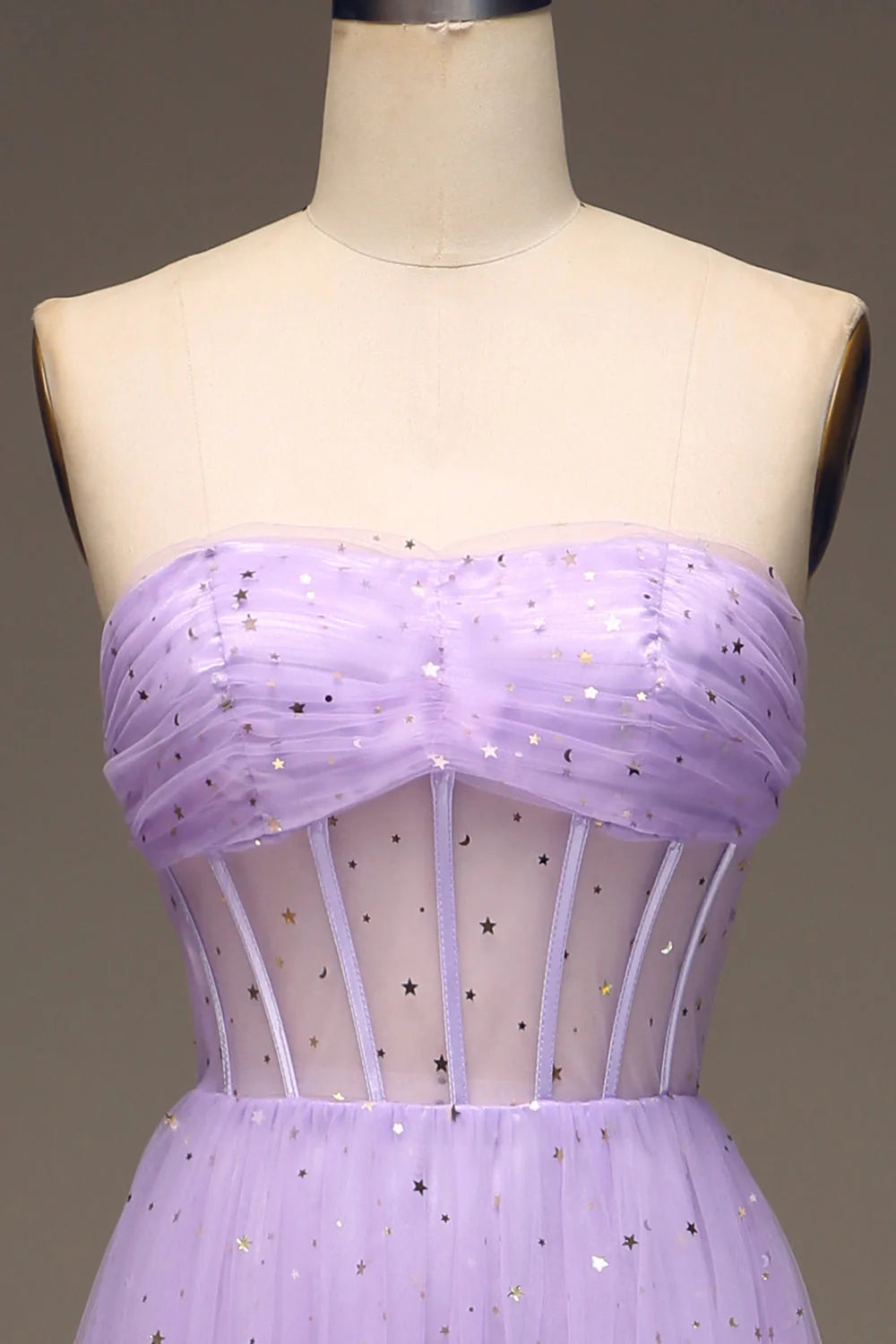 Close-up detail of the strapless sweetheart neckline and corset lacing on the purple dress.