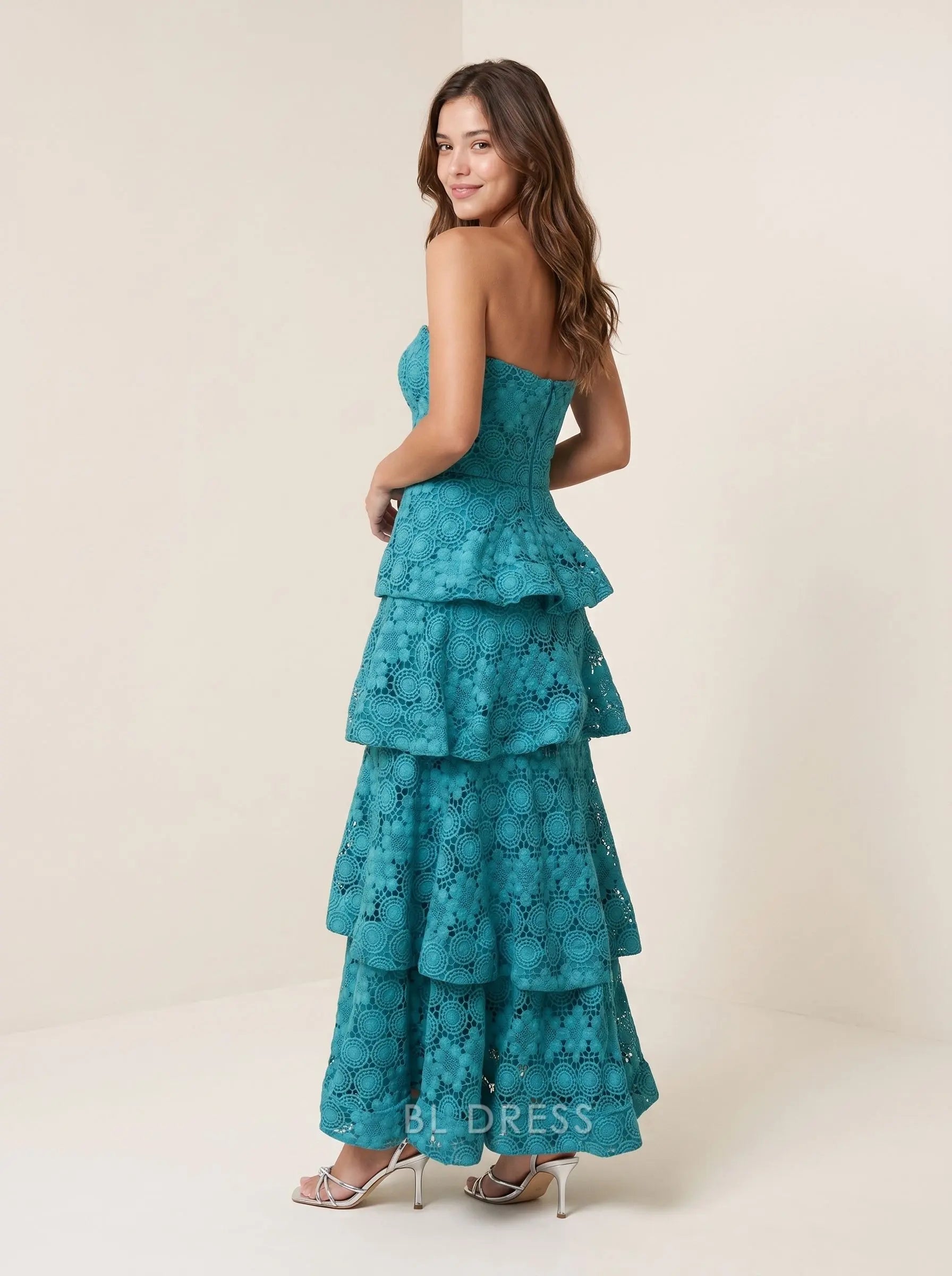 Back view of teal strapless tiered floral lace A-line prom dress on a woman.