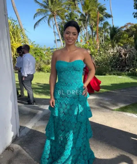 Close-up of intricate tiered floral lace on the teal prom dress.