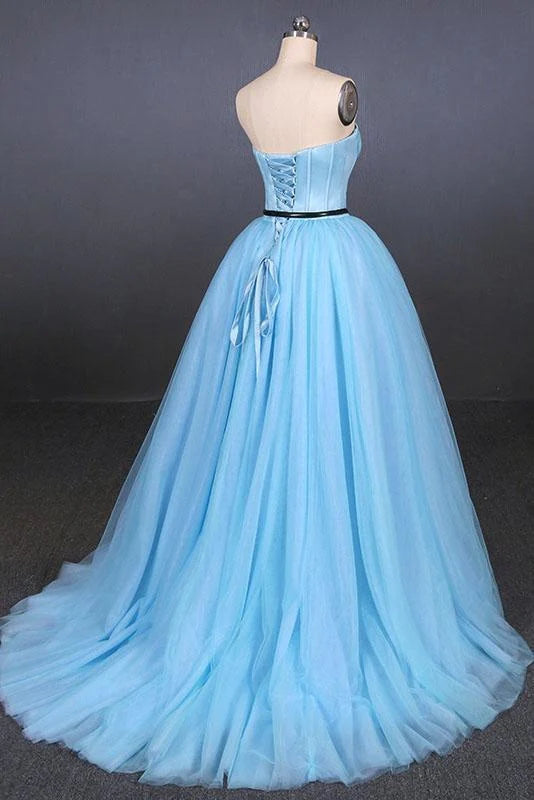 Full view of a strapless A-line tulle prom dress on a model.
