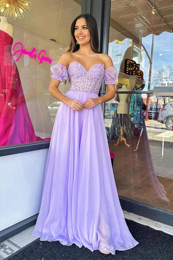 Model wearing a lilac A-line strapless tulle prom dress, full length view.