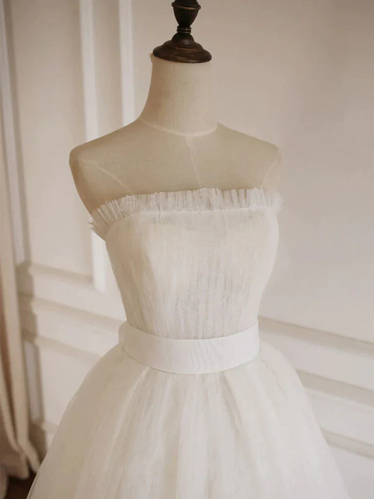 Side profile of a long strapless tulle formal gown.