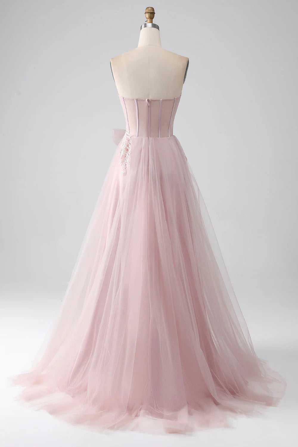 Blush pink A-line strapless prom dress, side view showing flowing tulle skirt.