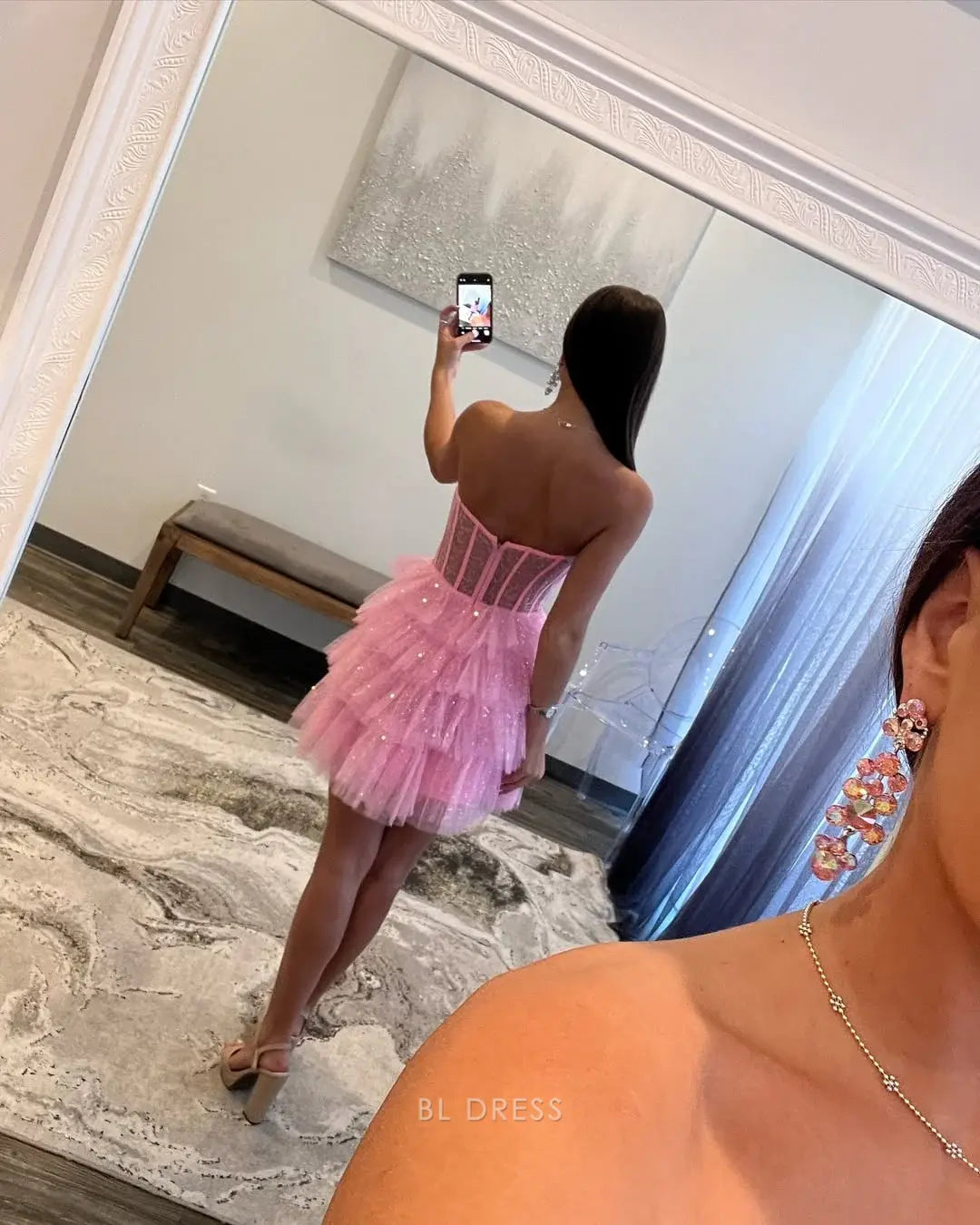 Model wearing a short A-line strapless prom dress.