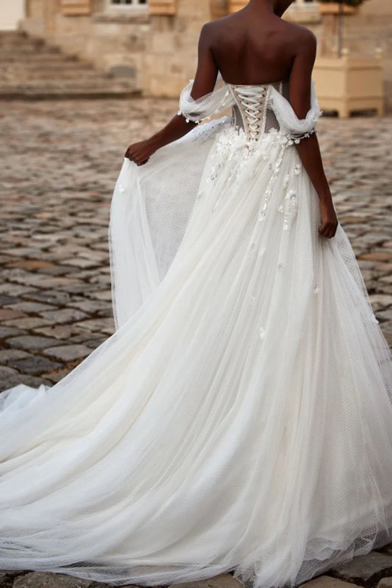 Back view of A-line wedding dress showing sweep train and delicate appliques.
