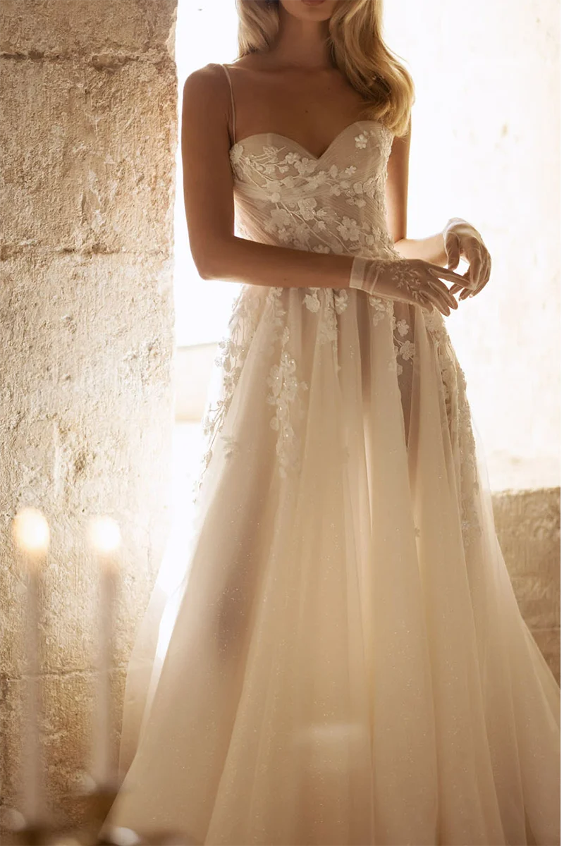 Close-up of the sweetheart neckline and intricate appliques on the wedding dress.