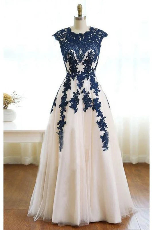Woman wearing an elegant A-line tulle prom dress with appliques and a sweetheart neckline.
