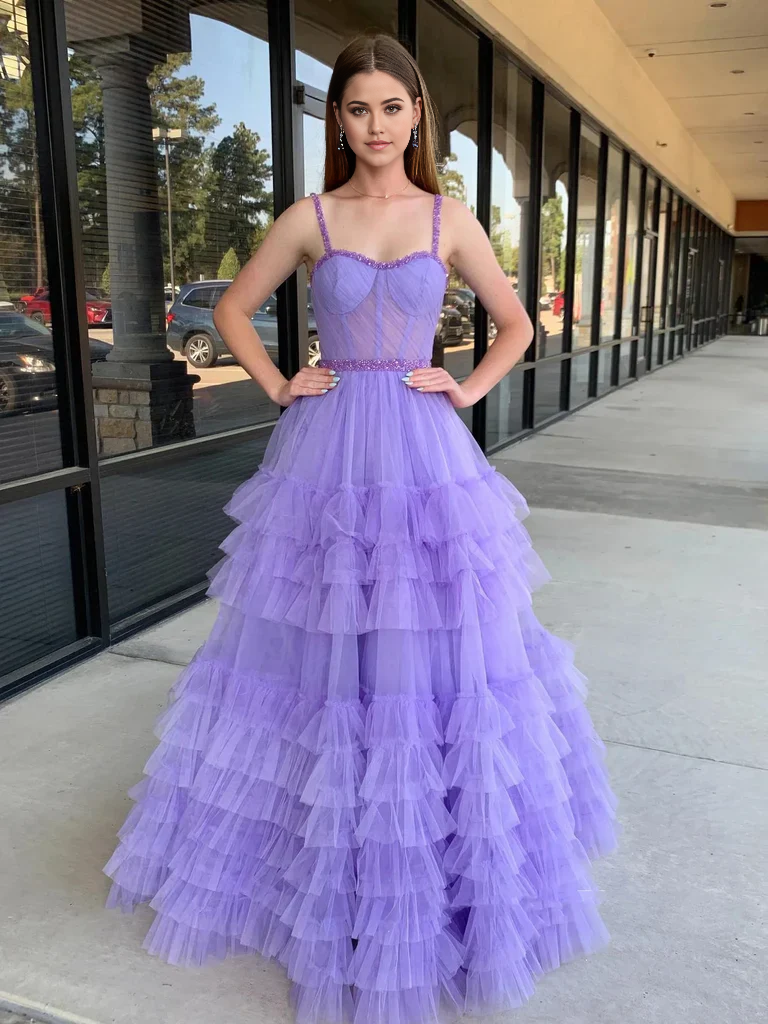 Woman wearing an elegant A-line sweetheart neck beaded long prom dress in blue.