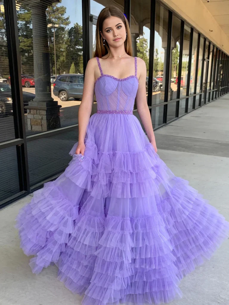 Back view of a woman in a blue A-line sweetheart neck beaded long prom dress.