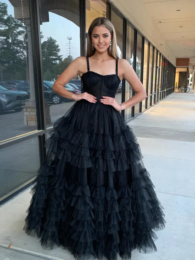 Woman posing in a red A-line sweetheart neck beaded long prom dress.