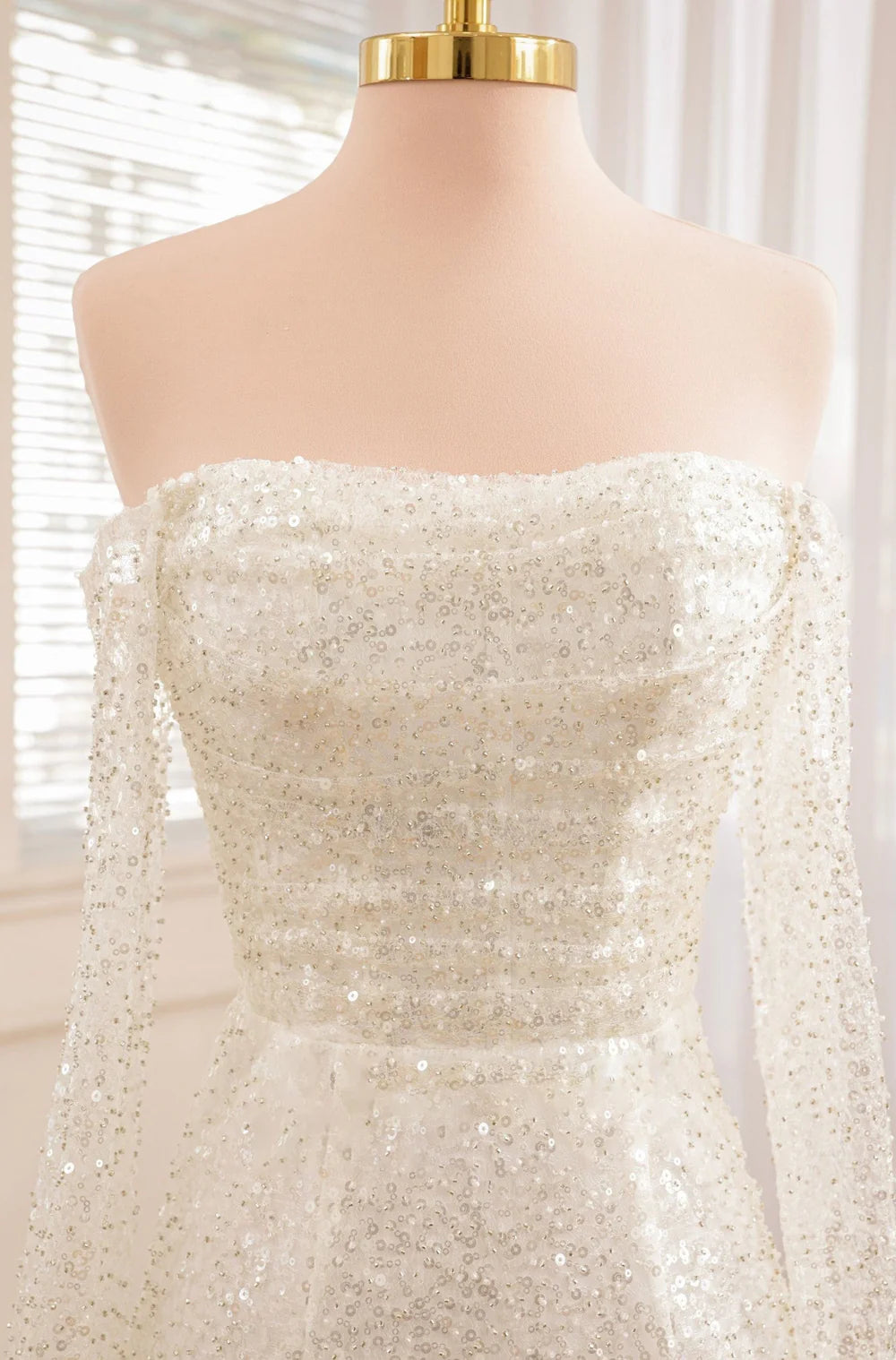 Model wearing the short wedding dress in a strapless style, with sleeves removed.