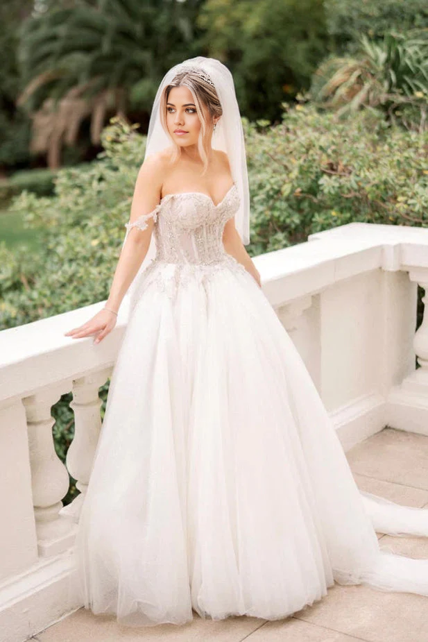 Side view of A-line wedding dress showcasing flowing tulle skirt and beaded bodice.