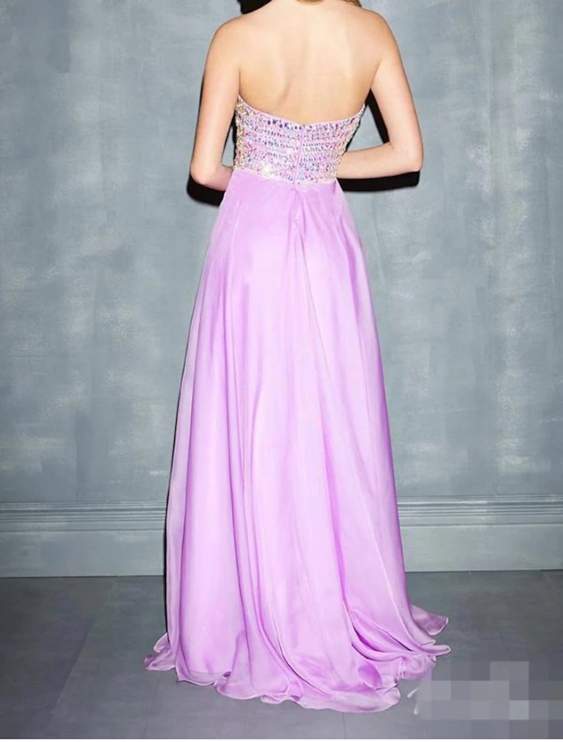 Back view of the glittering A-line evening gown with sweep train.