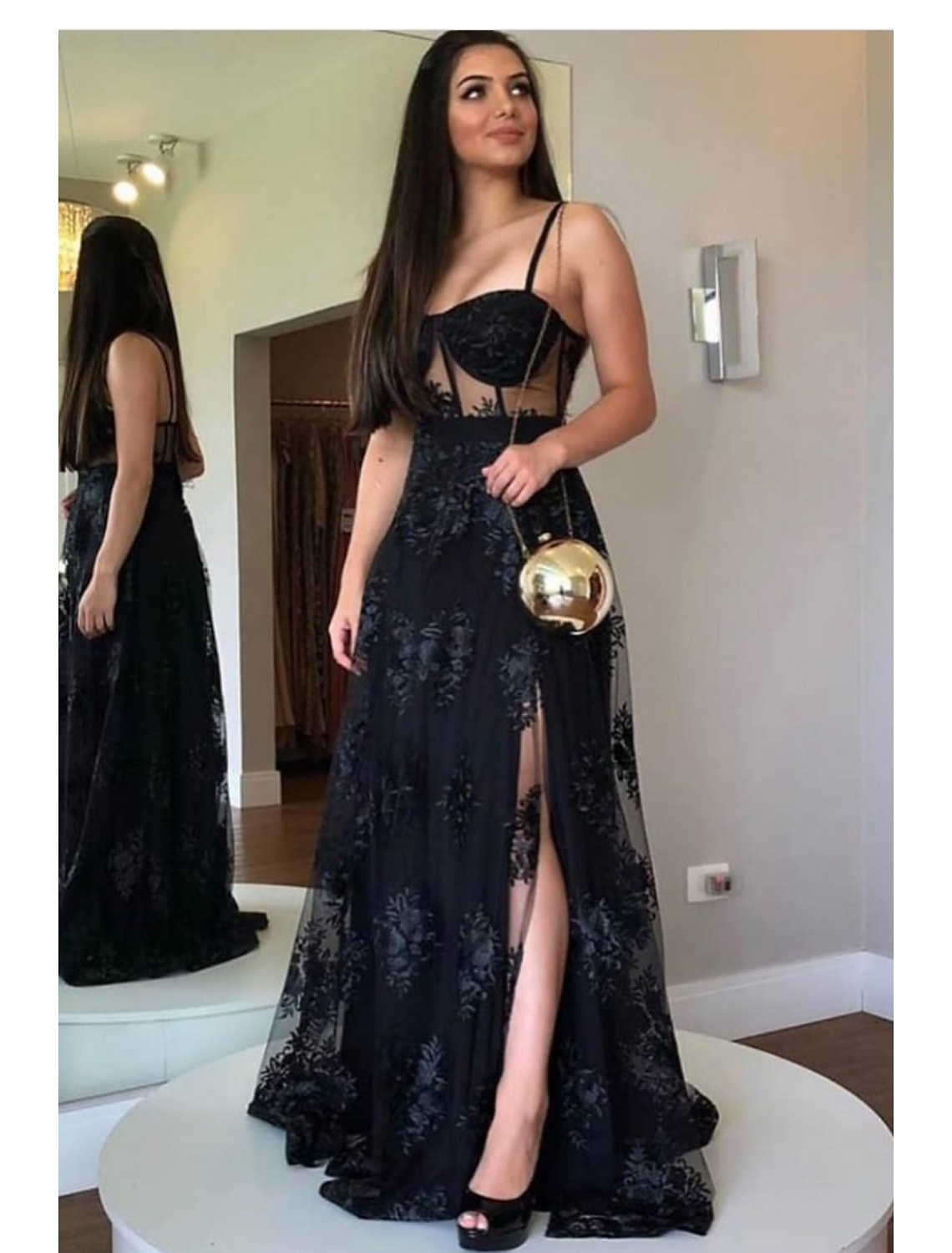 Woman wearing a dark A-line floor-length prom dress with sweetheart neckline, cut-out details, and lace back.