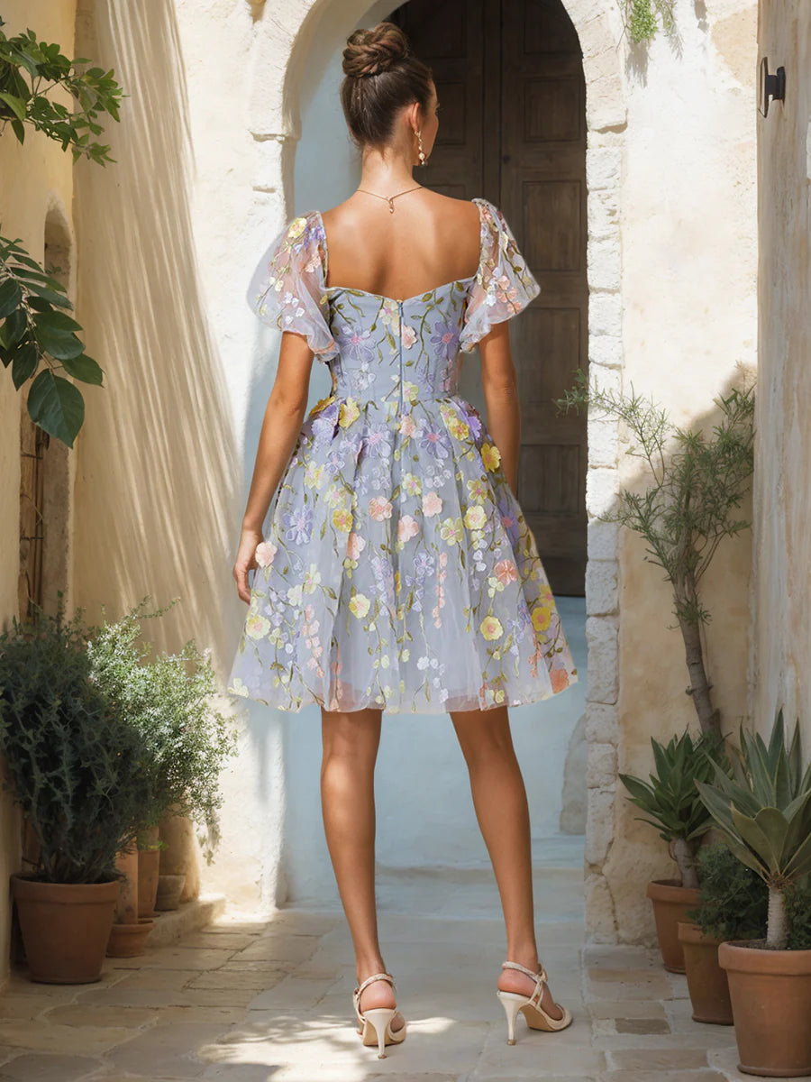 Close-up of embroidered details on a white knee-length homecoming dress.