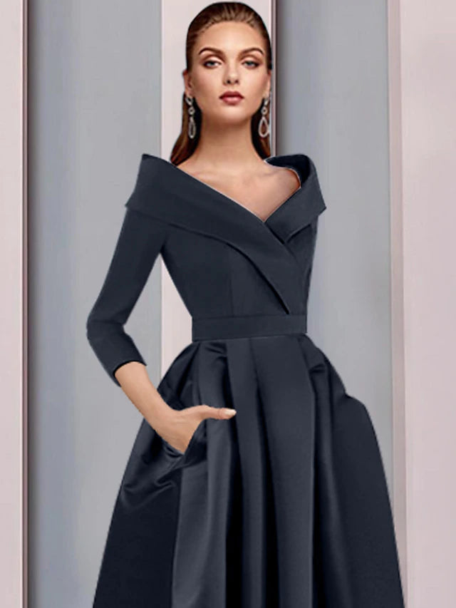Side view of the elegant high-low tea length satin dress with flowing pleats.