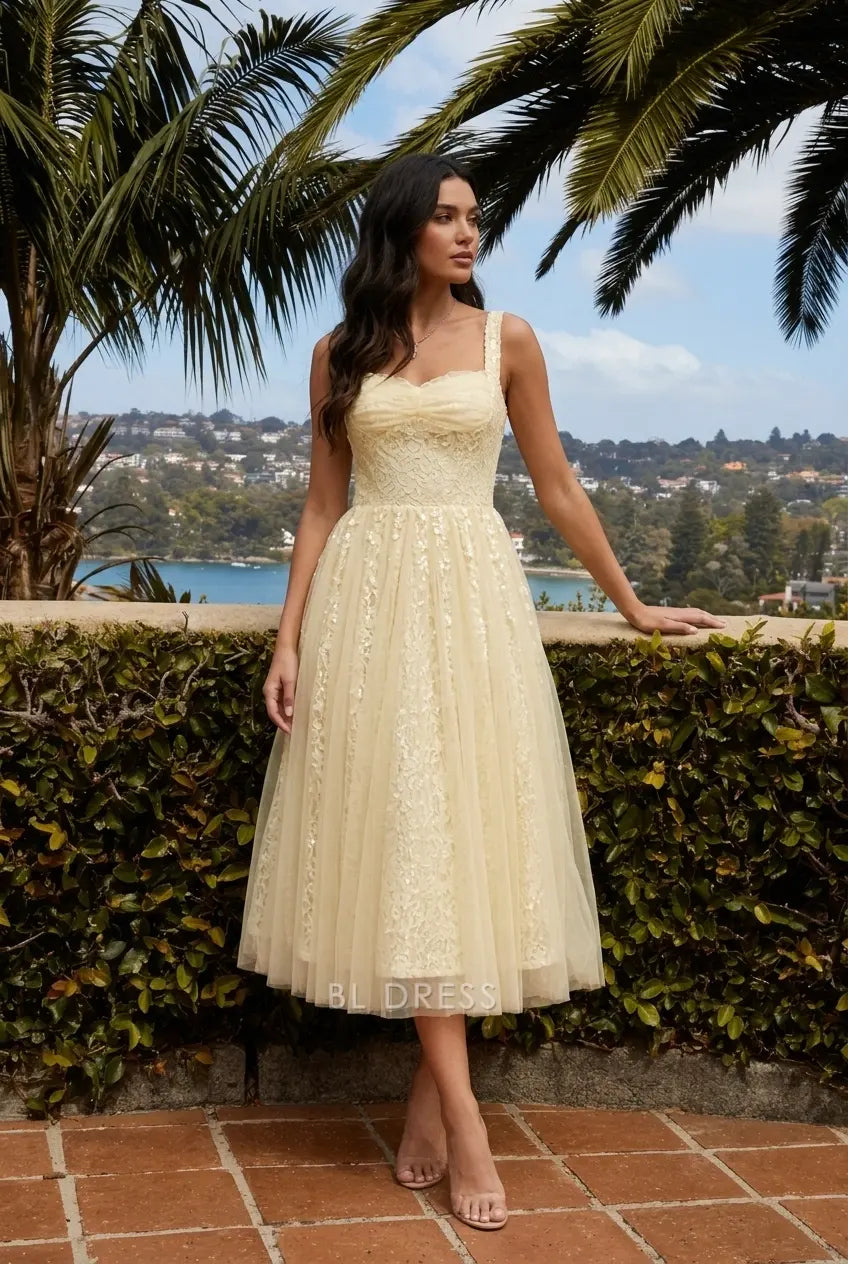 Light yellow A-line midi gown with sweetheart neckline, lace bodice, and tulle skirt.