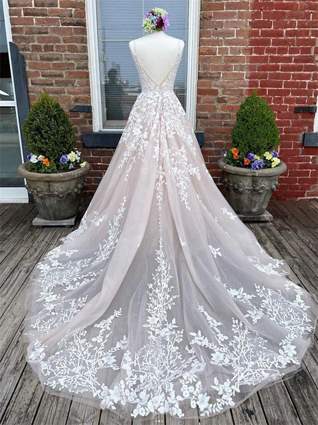 Back view of a white A-line wedding dress featuring lace appliques, button details, and a court train.