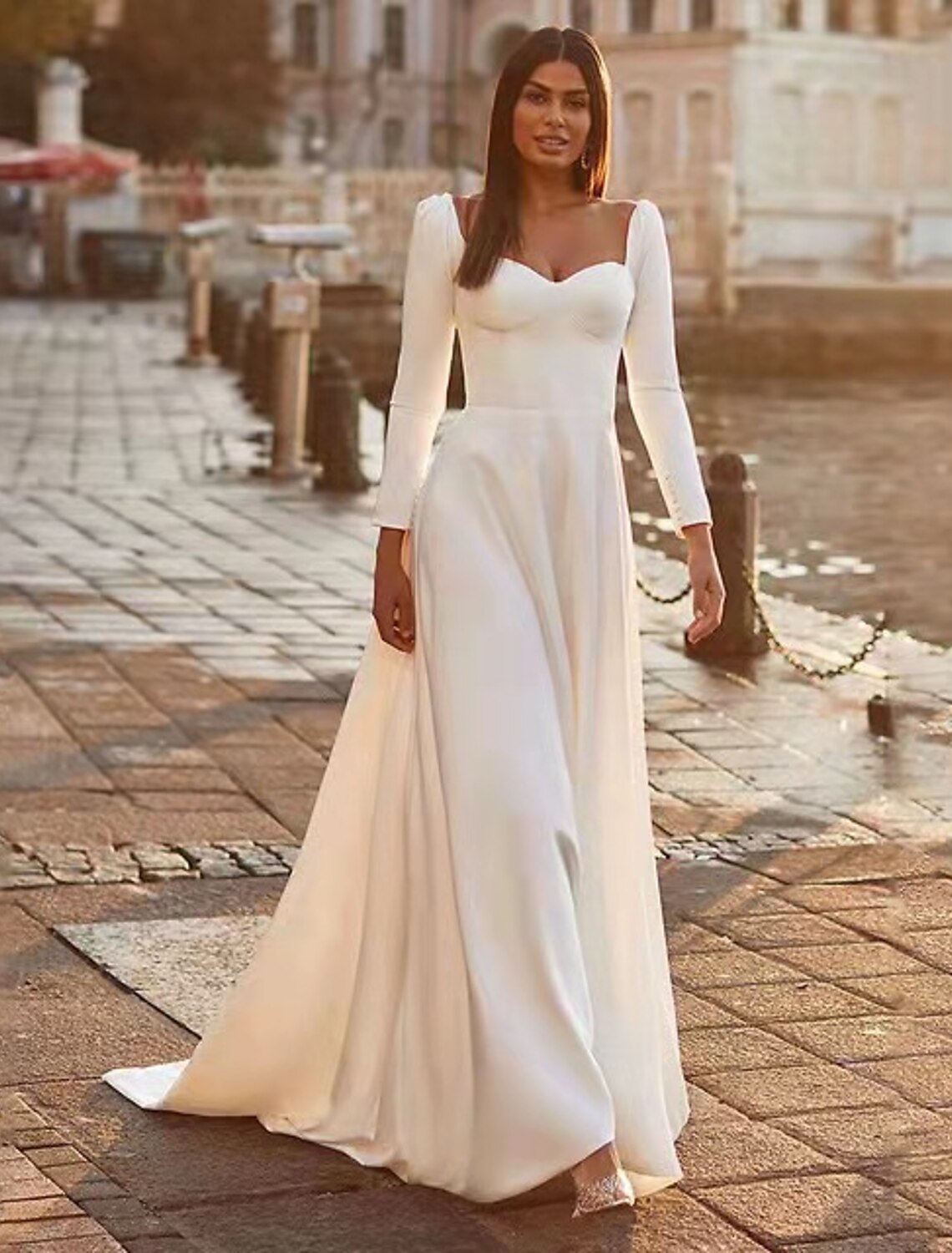 Side profile of the A-line wedding dress with a flowing train.