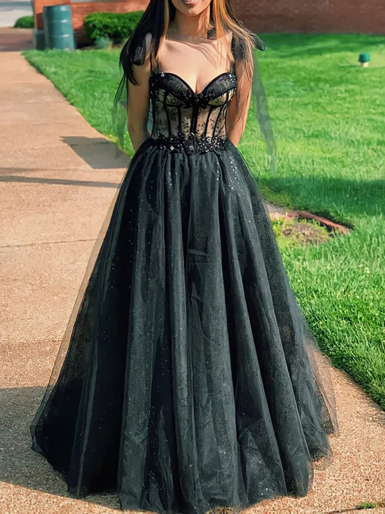 Woman wearing a long A-line tulle prom dress with a sweetheart neckline.