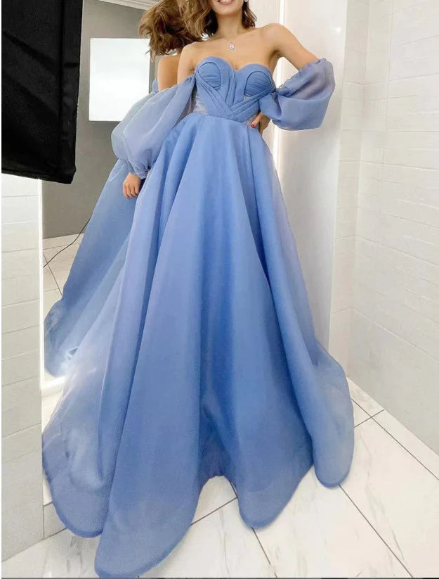 Model wearing a long, light blue sweetheart off-shoulder chiffon A-line prom dress.