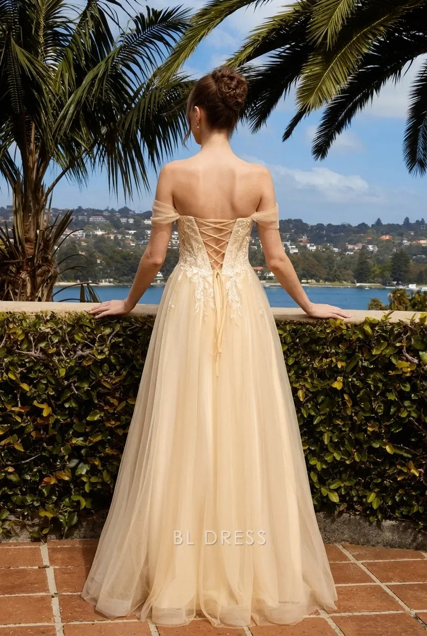 Side view of champagne A-line dress, showcasing high slit and delicate off-shoulder straps.