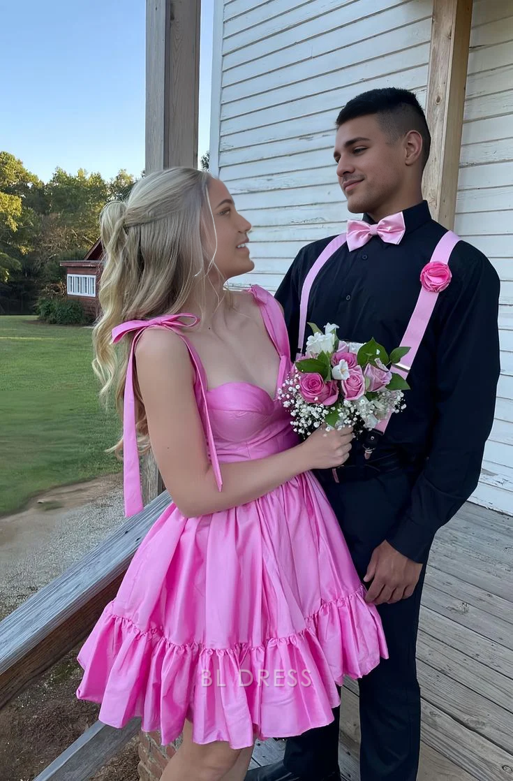 Woman wearing a short pink A-line sweetheart homecoming dress.