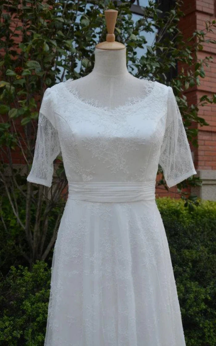 Close-up of the intricate tulle ruching and illusion sleeve detail on a wedding dress.