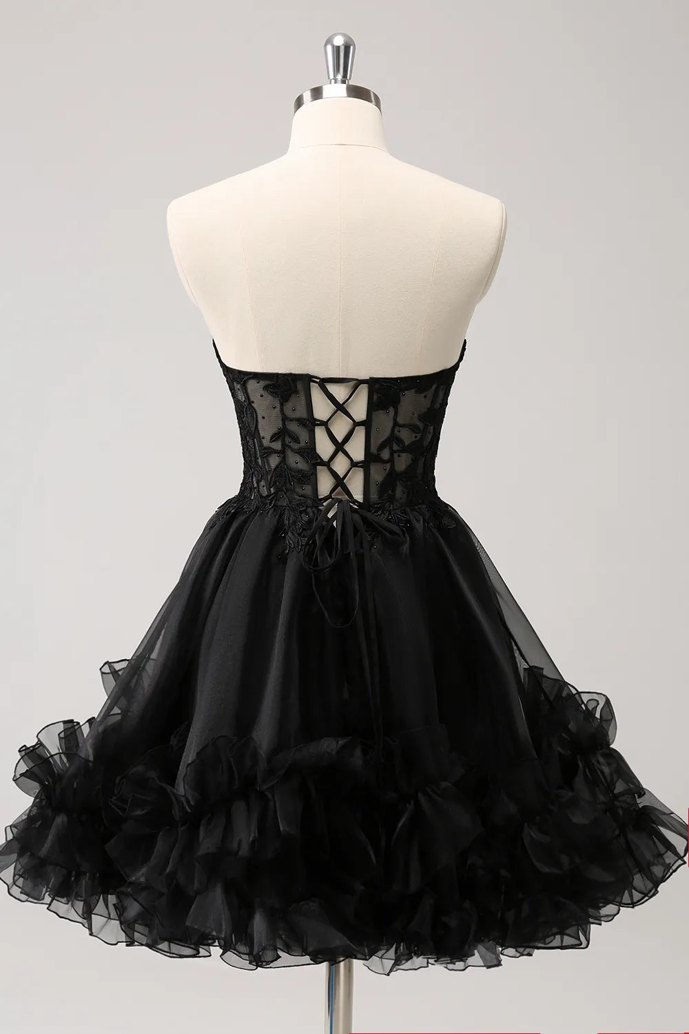 Back view of black corset homecoming dress with appliques.