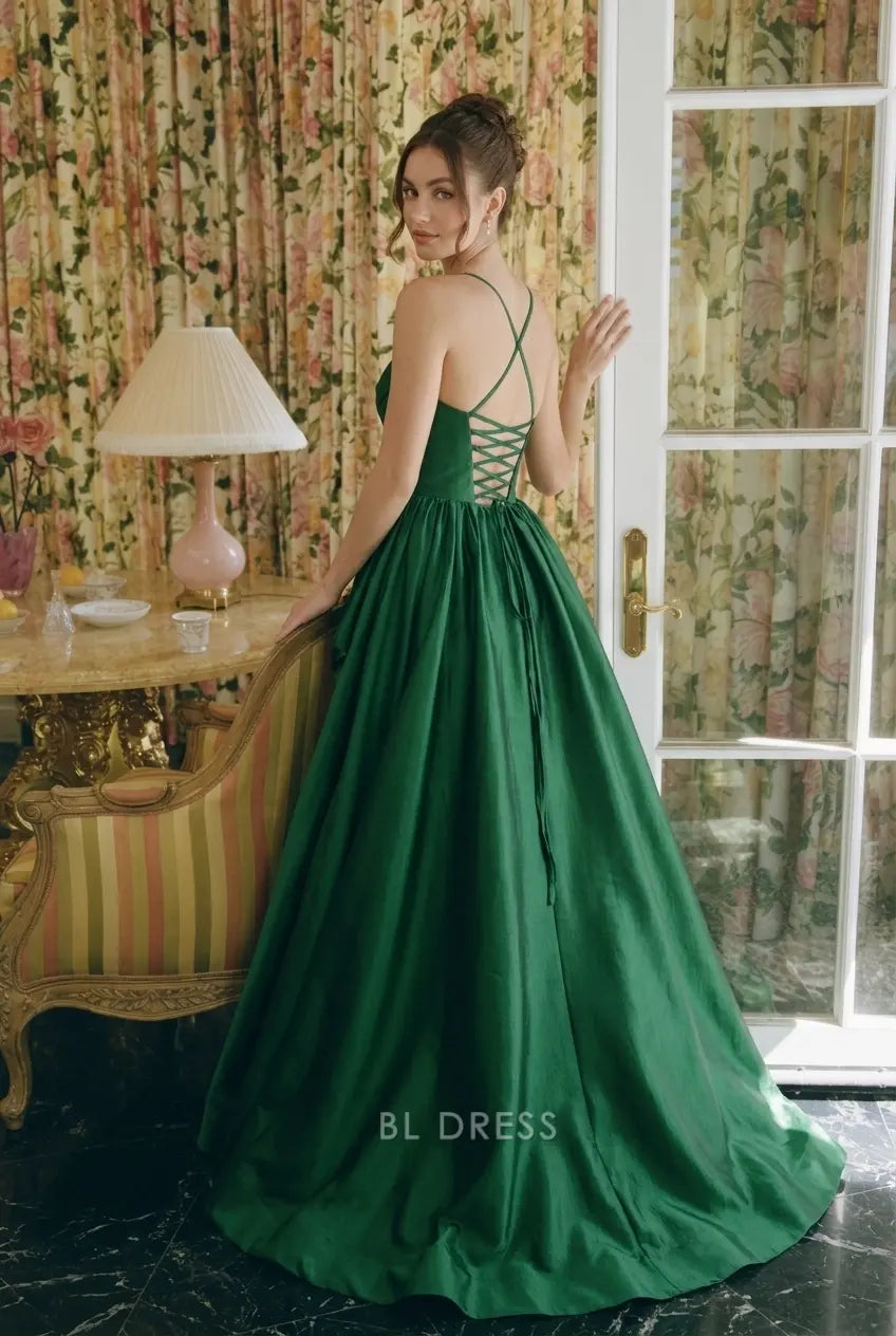 Side view of emerald green high-low prom gown, showing ruffled hem and elegant silhouette.