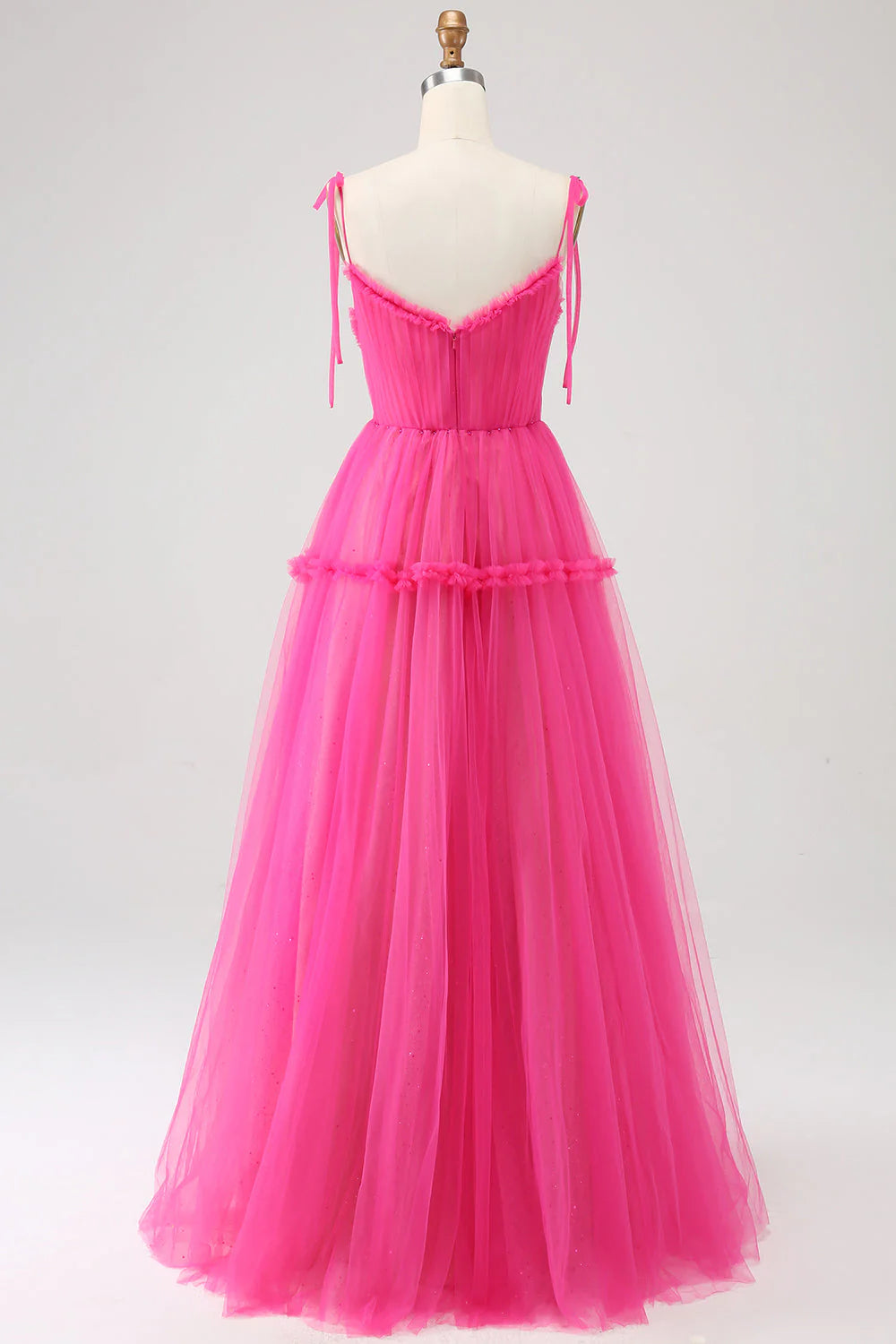 Side view of a fuchsia A-line ruffled tulle long prom dress.