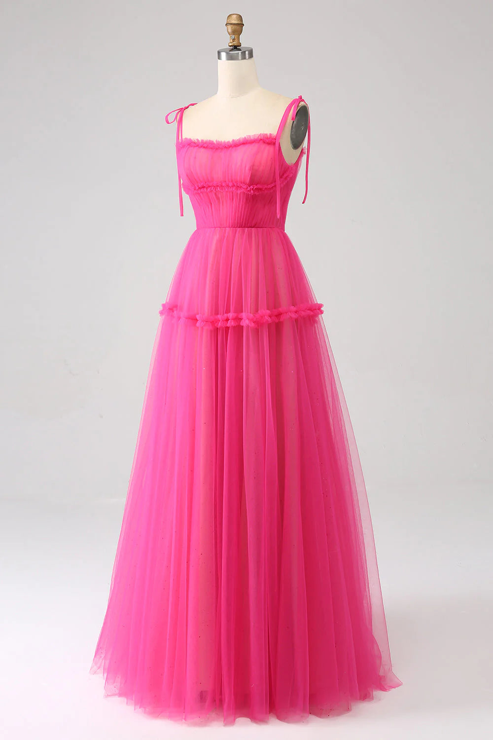 Back view of a fuchsia A-line ruffled tulle long prom dress.