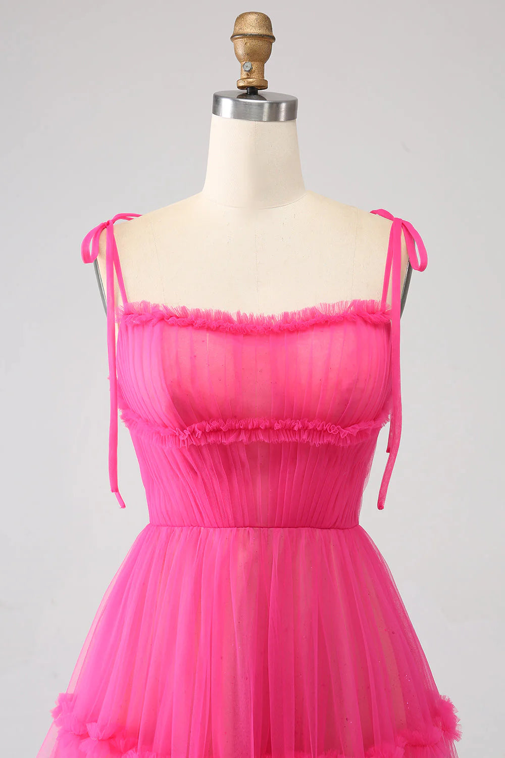 Close-up of the ruffled tulle fabric on a fuchsia prom dress.