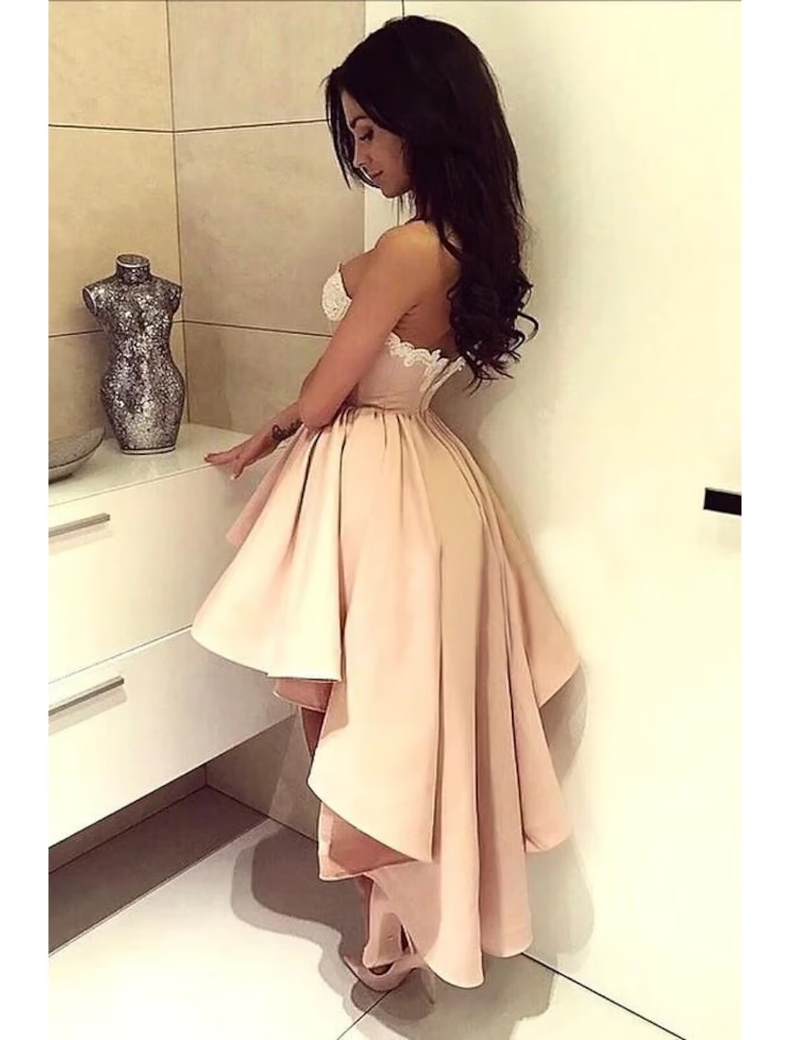 Back view of a satin homecoming dress showing backless design and delicate appliques.