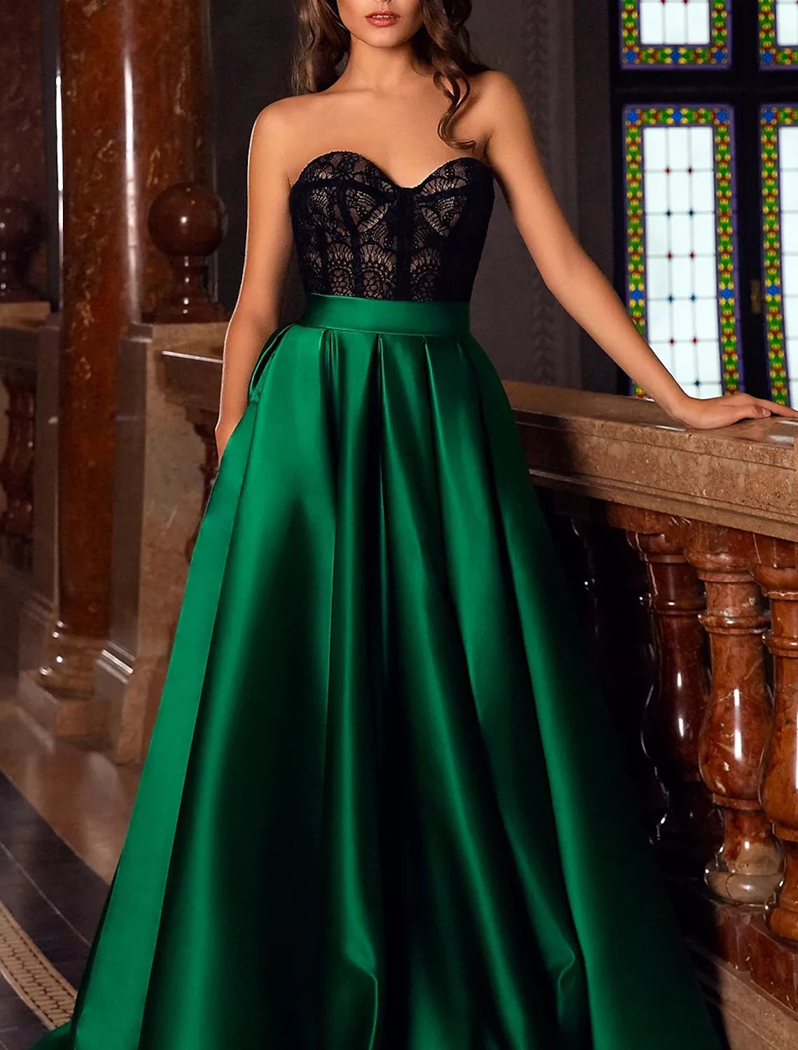 Back view of a woman wearing a satin A-line gown with a court train.