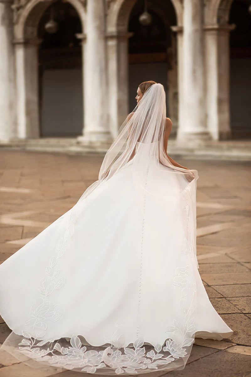 Full length view of an A-line sweetheart satin long sleeve wedding dress.