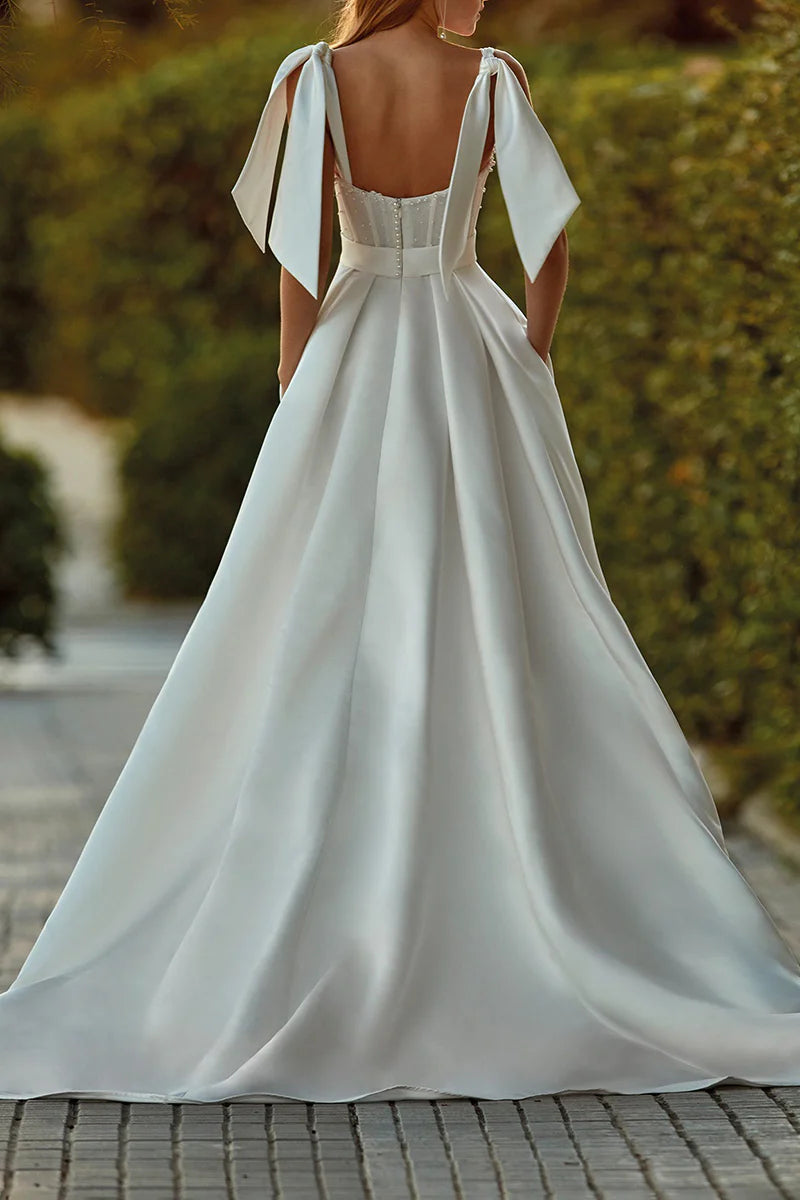 Side profile of A-line satin bridal gown with flowing skirt.