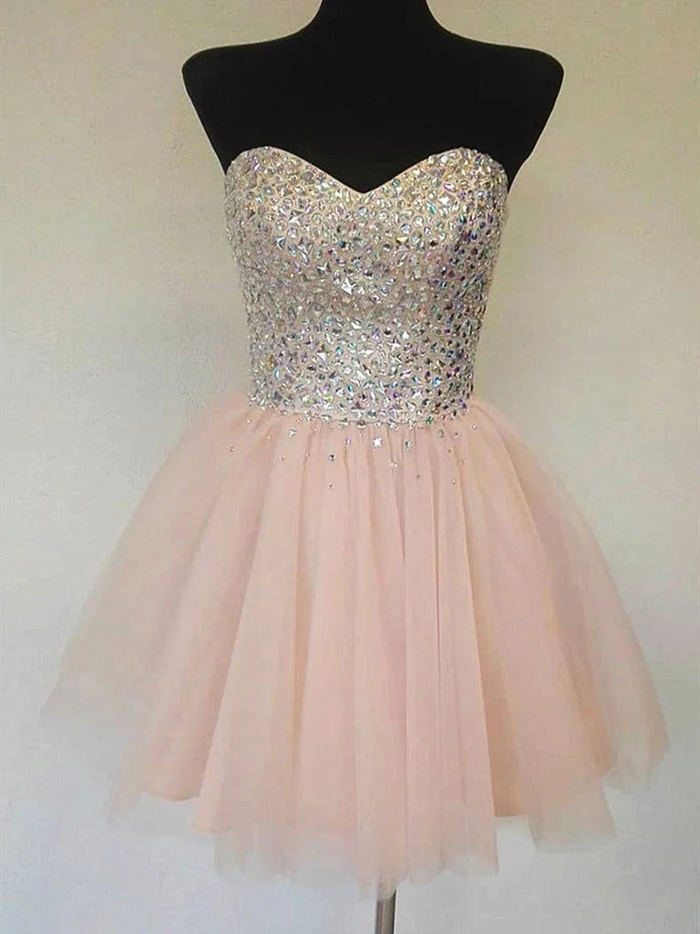 Woman wearing a champagne A-line short dress with sequins and a sweetheart neckline.