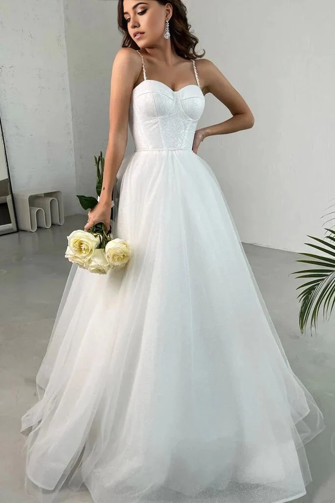 Woman wearing a white A-line sweetheart neck long tulle prom dress.