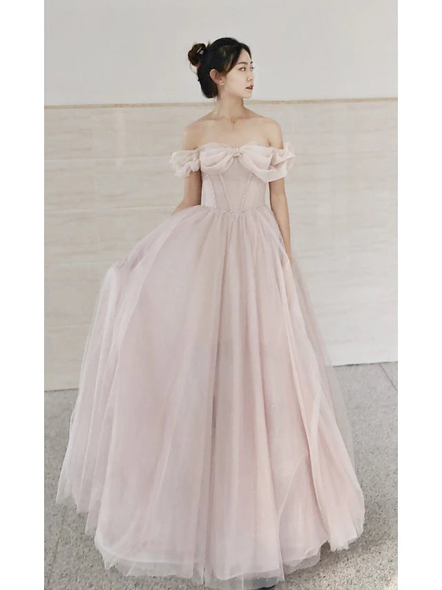 Model wearing an elegant A-line sweetheart short sleeve tulle prom dress with beading.