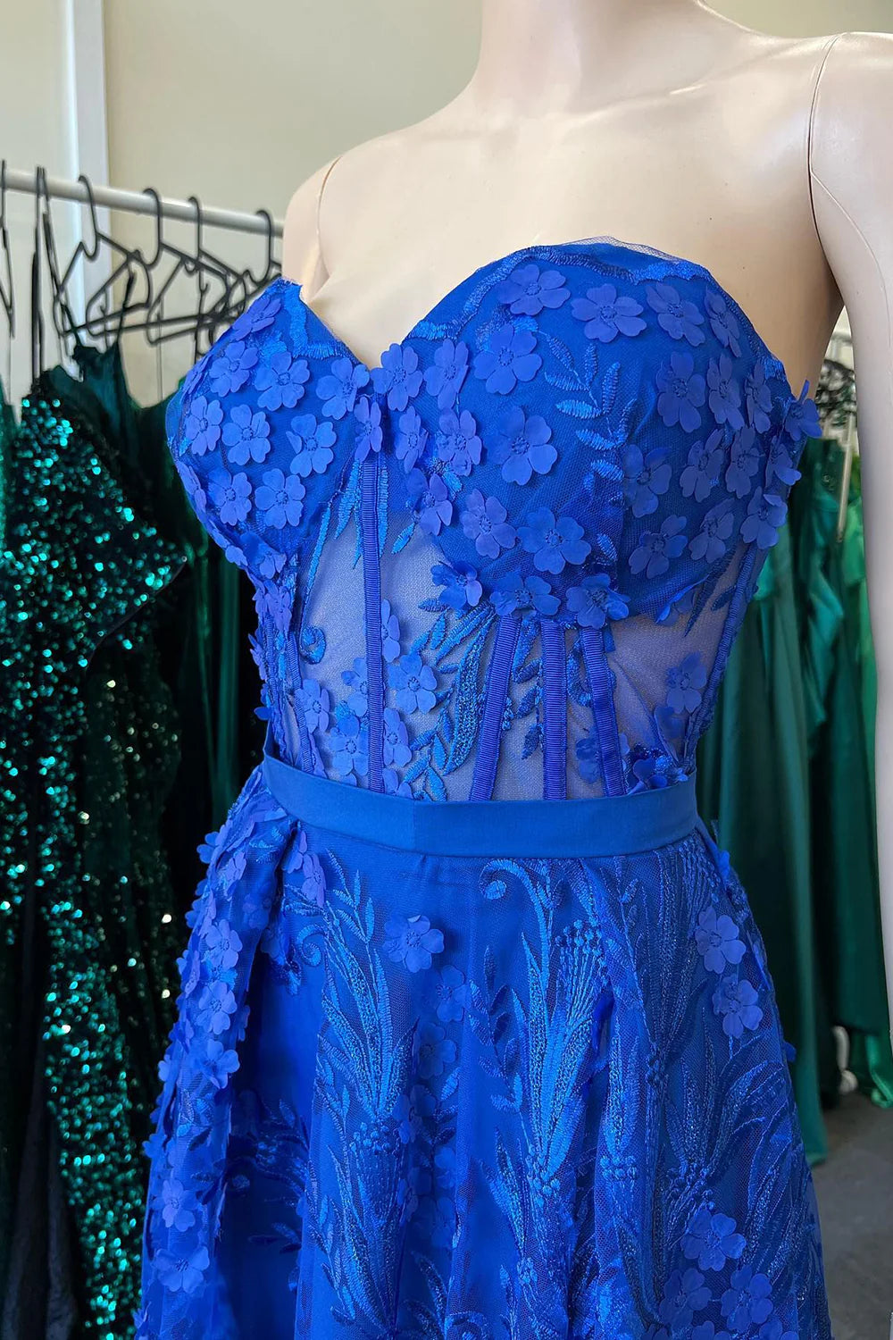 Side view of a royal blue long prom dress featuring appliques and a sweetheart neckline.