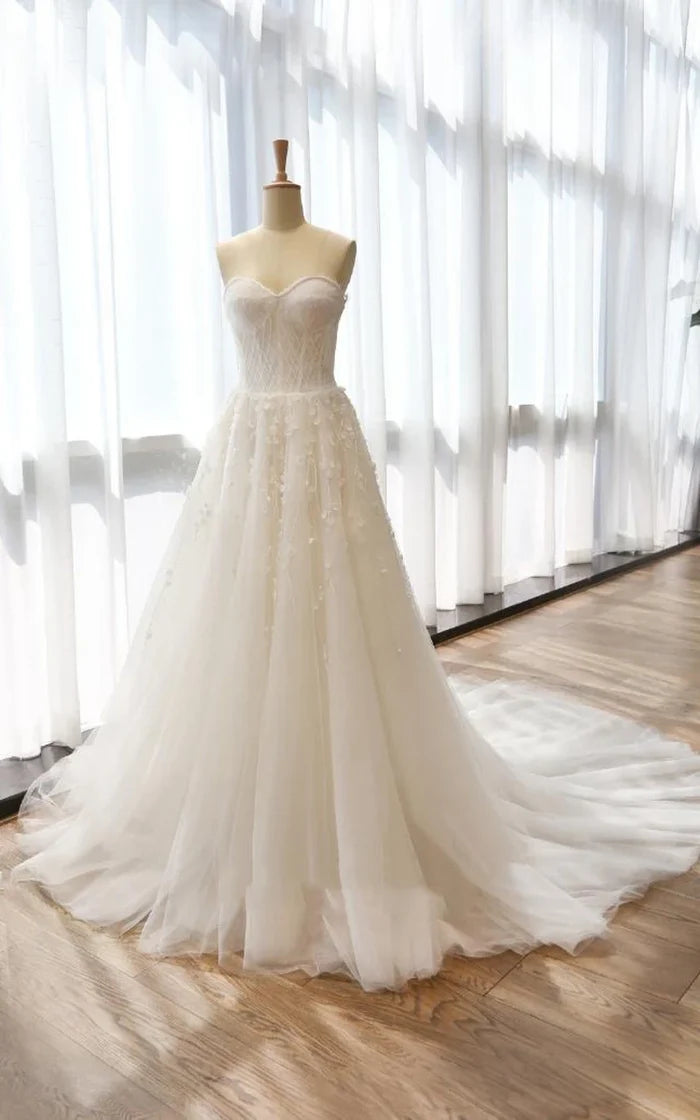 Elegant A-line tea-length dress with bell flower, tulle, lace, and satin details.