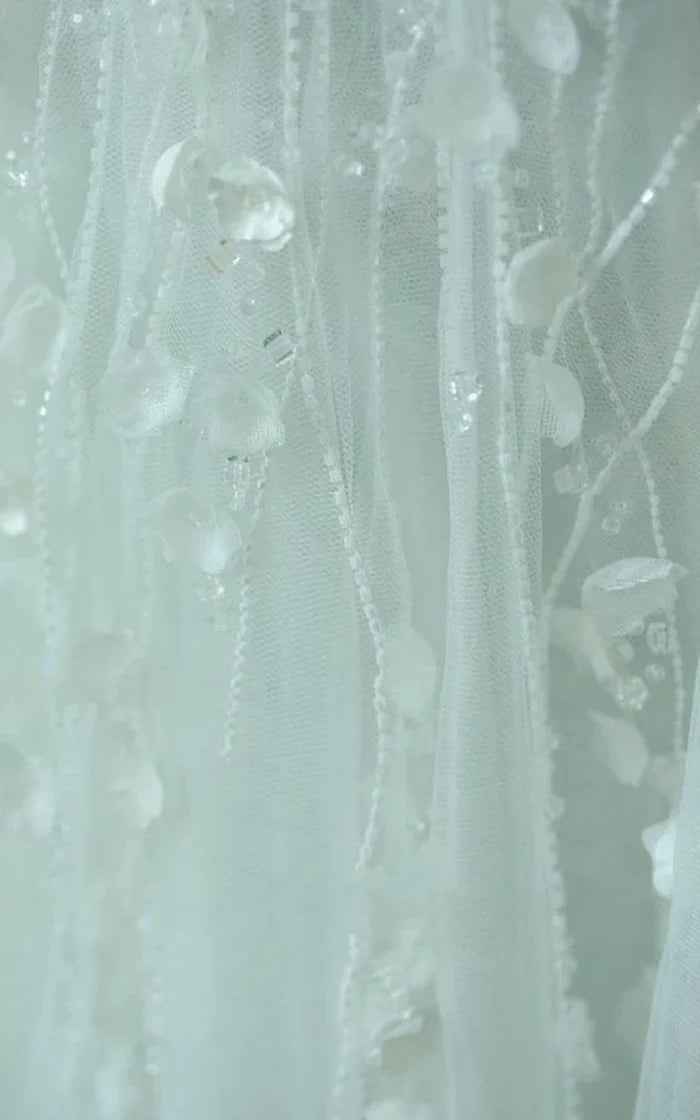 Close-up of delicate lace and bell flower embellishments on the dress.