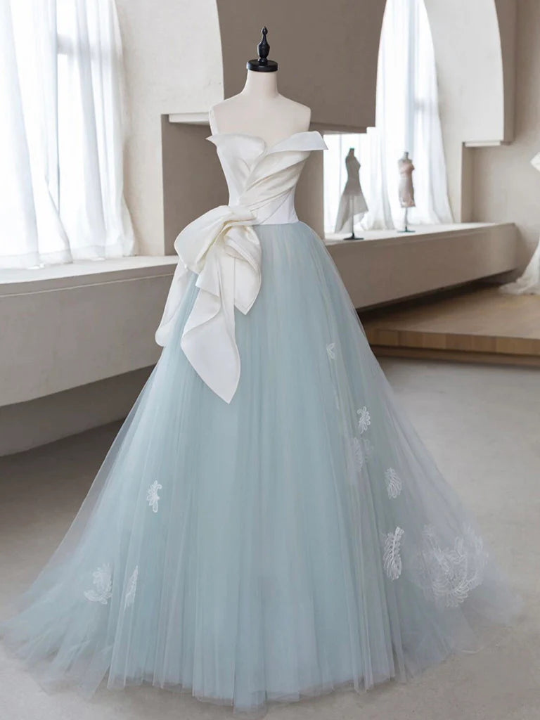 Model posing in a flowing A-line tulle prom dress.