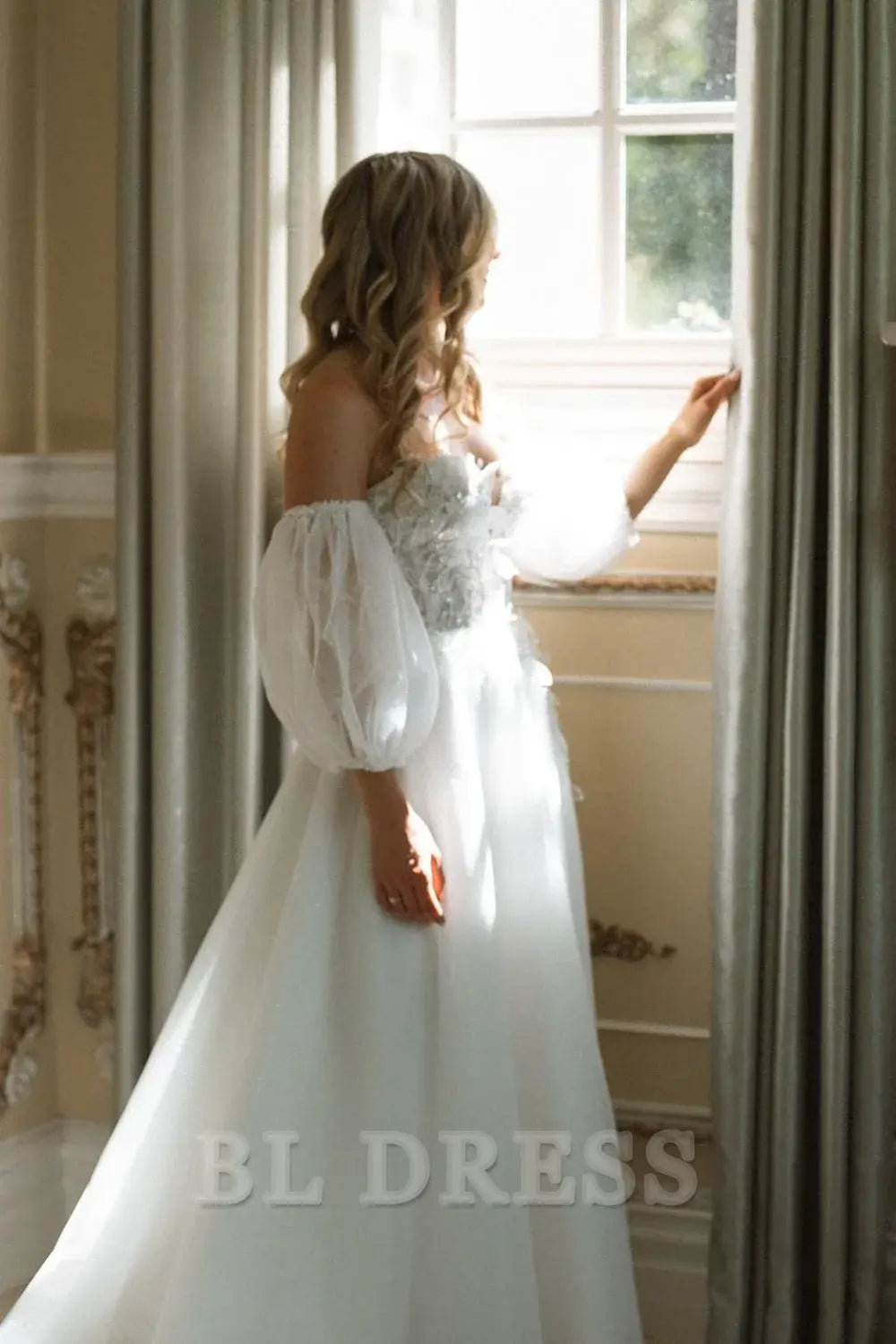 Full length view of an elegant white long bridal gown featuring appliques.