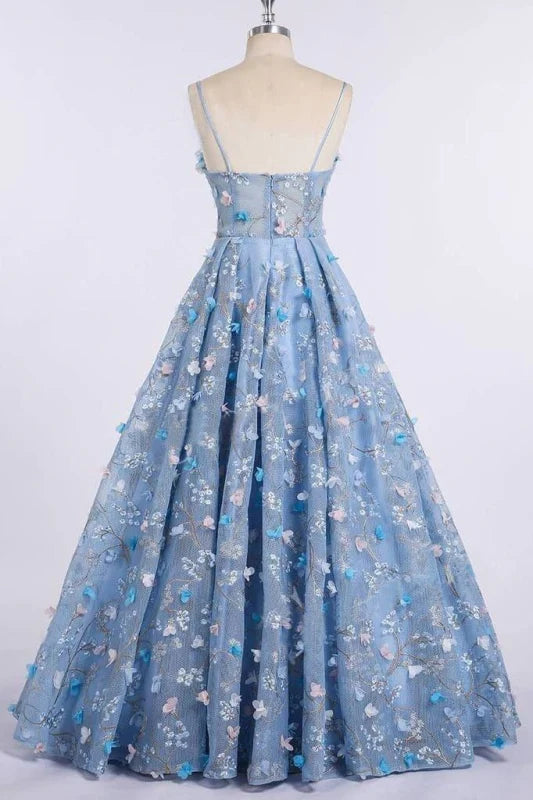 Back view of a woman in a floral lace spaghetti strap formal gown.