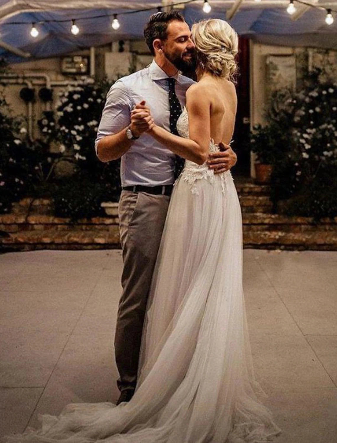 Back view of a lace beach wedding dress with sweep train.