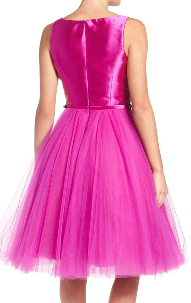 Side view of a woman in a short tulle homecoming gown.