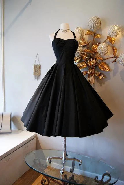 Woman wearing a blush A-line tea-length prom dress with spaghetti straps and a sweetheart neckline.